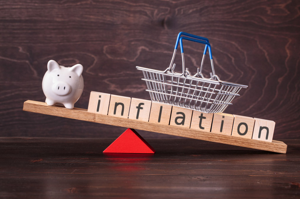 piggy bank and inflation building blocks in a scale